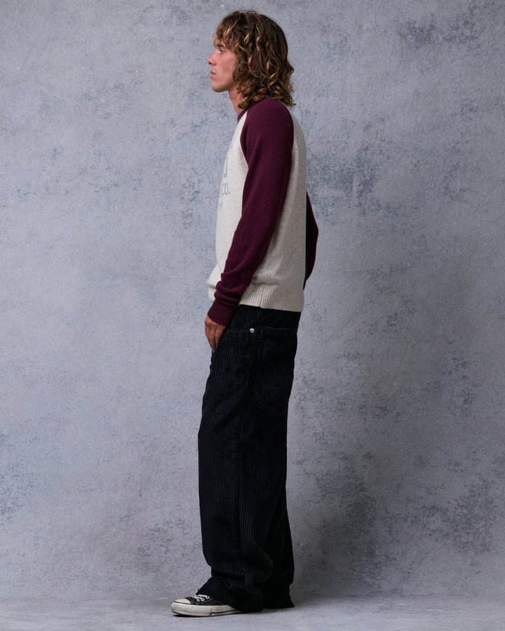 Model wearing black wide-leg corduroy pants with sneakers, side profile view