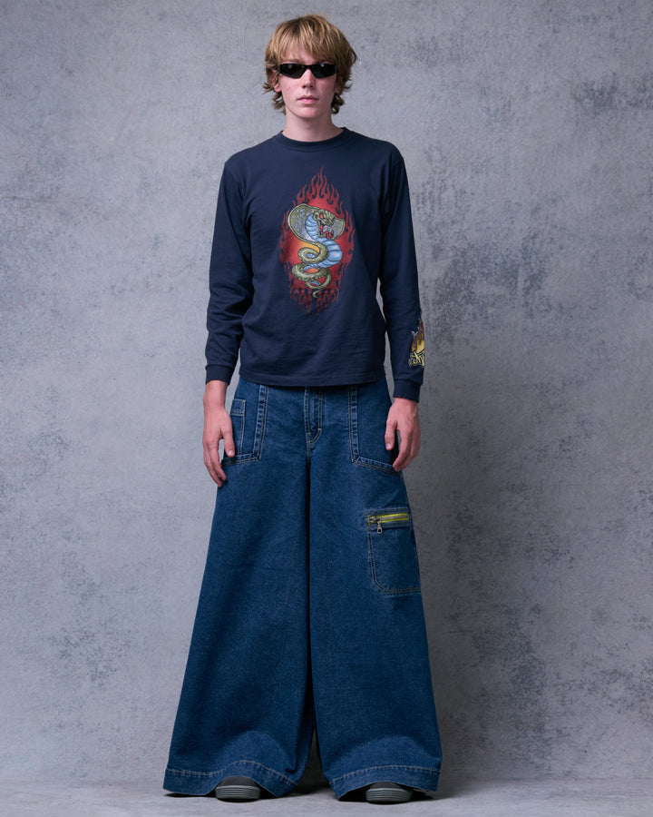 Model wearing the wide-leg dark stone jeans with a navy long-sleeve tee, front view showing a yellow zip pocket
