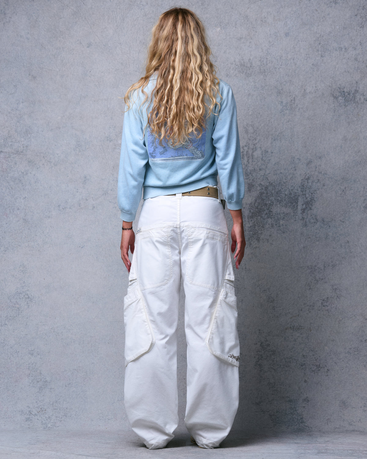 Model wearing natural off-white wide-leg cargo pants, straight back view showing back and side pockets