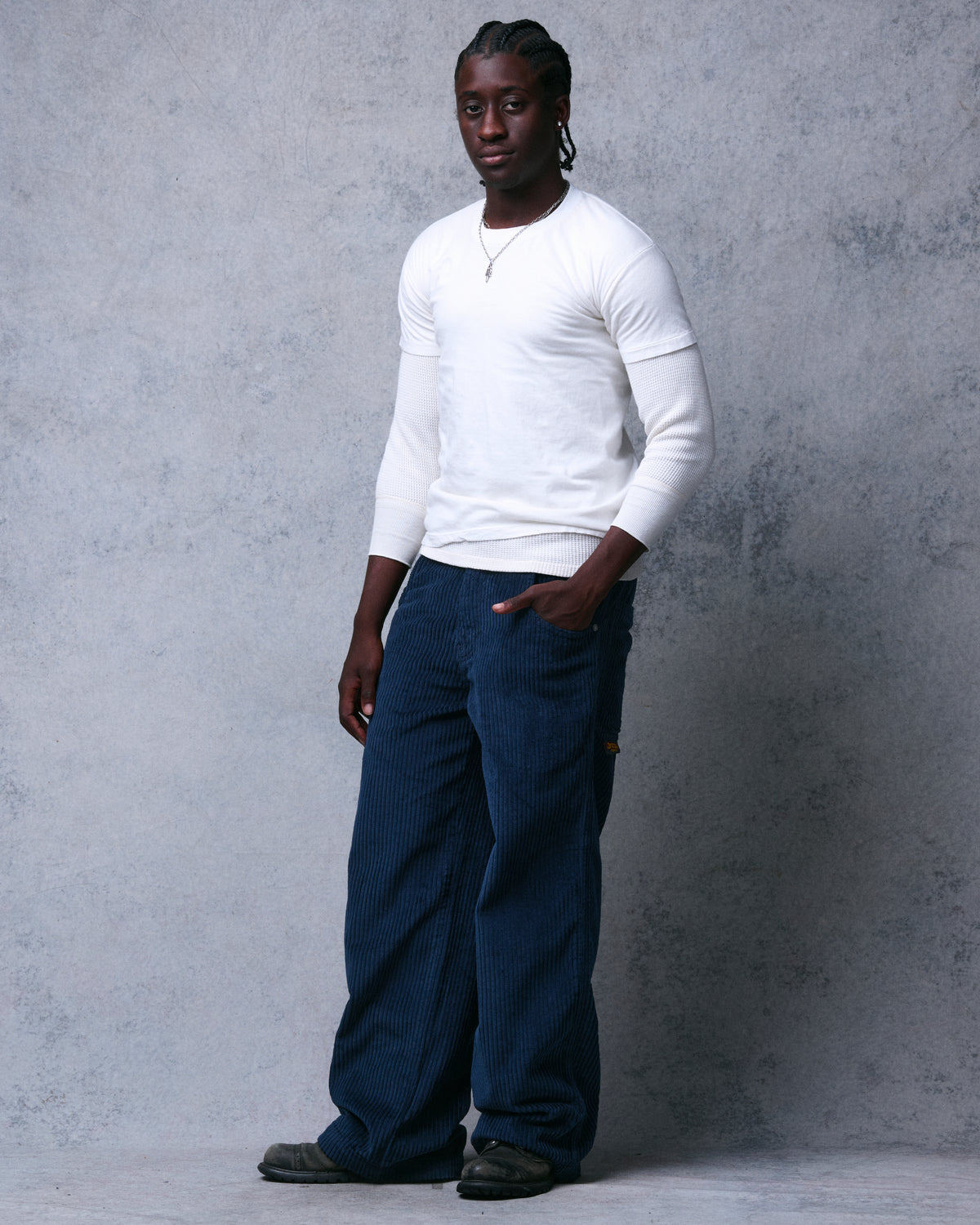 Model wearing navy wide-leg corduroy pants, three-quarter front view showing the full leg width down to boots