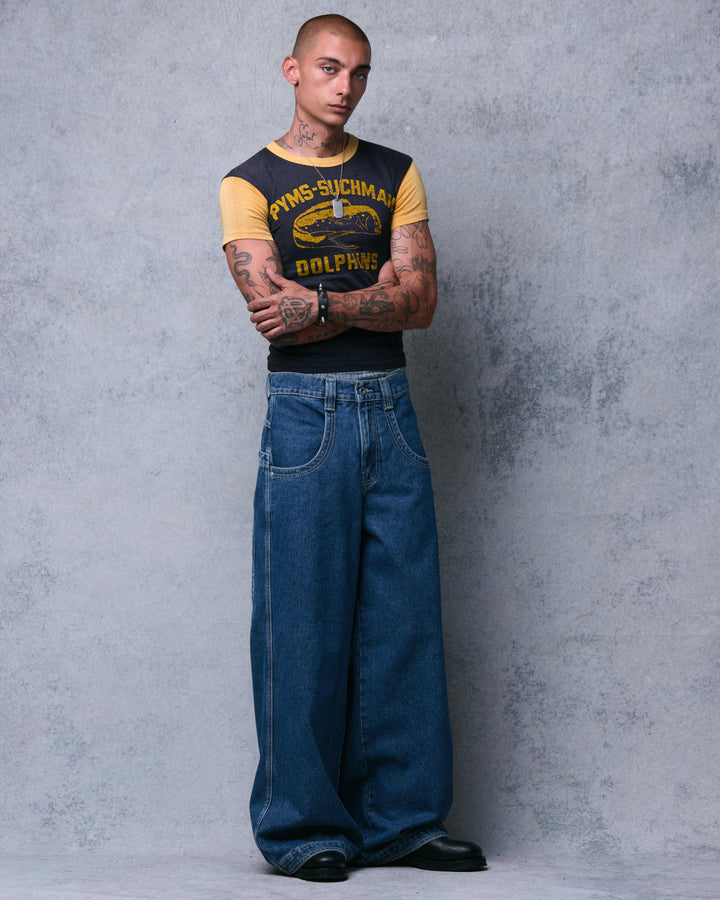 Model with arms crossed wearing dark stone wash wide-leg jeans, front view at a slight angle