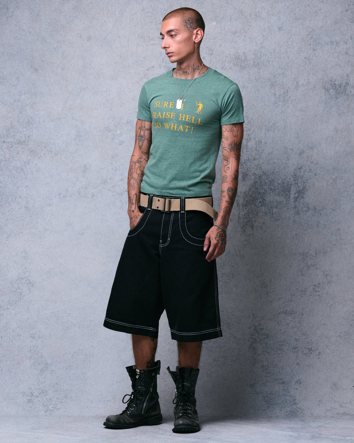 Model wearing black wide-leg denim shorts with a tan belt, three-quarter front view looking down