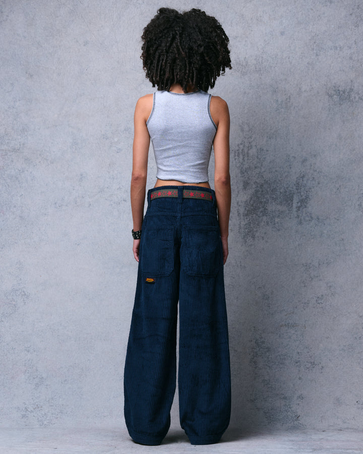 Model wearing navy wide-leg corduroy pants, full back view in the studio showing both back pockets