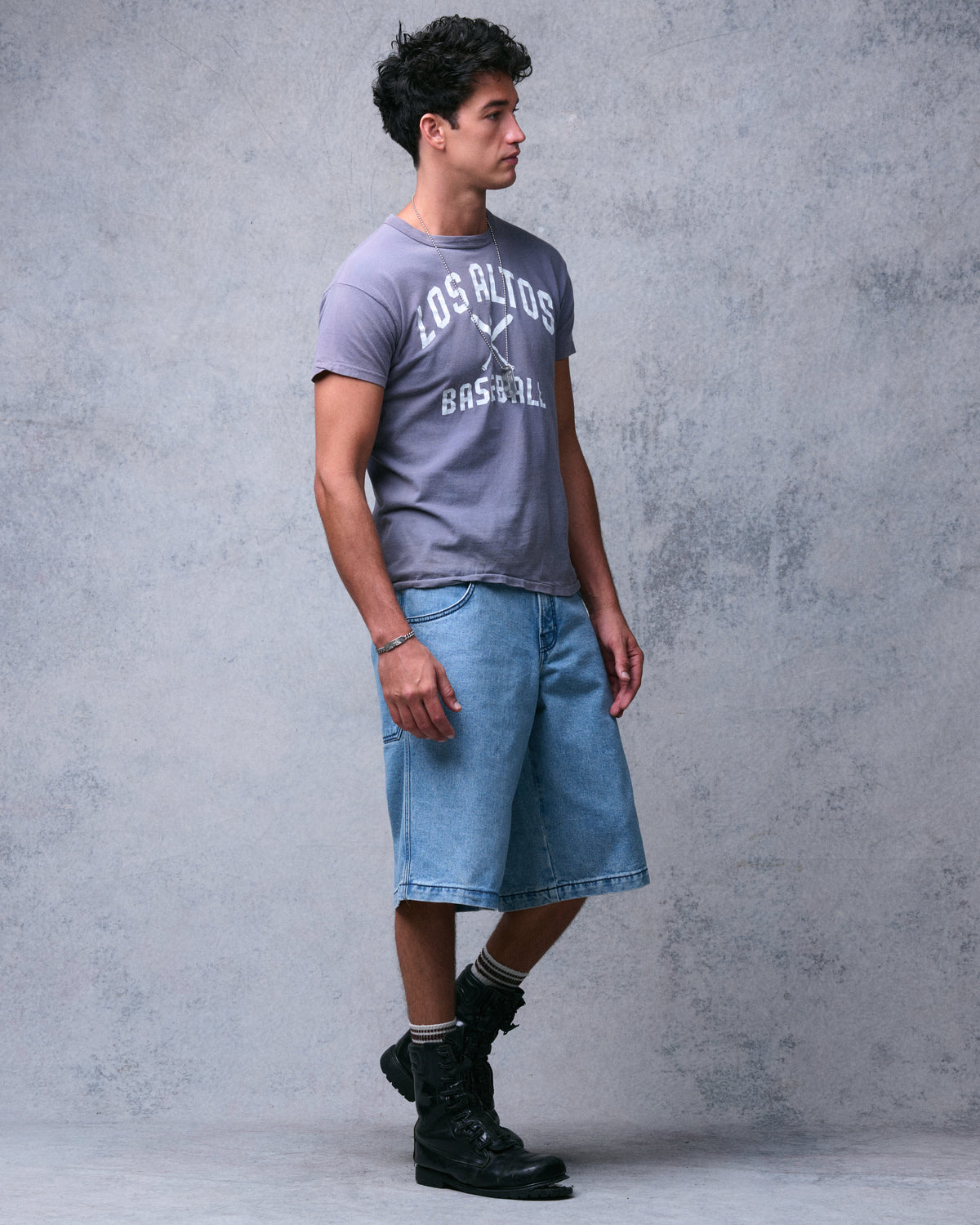 Model mid-step in the light blue wide-leg denim shorts, three-quarter side view