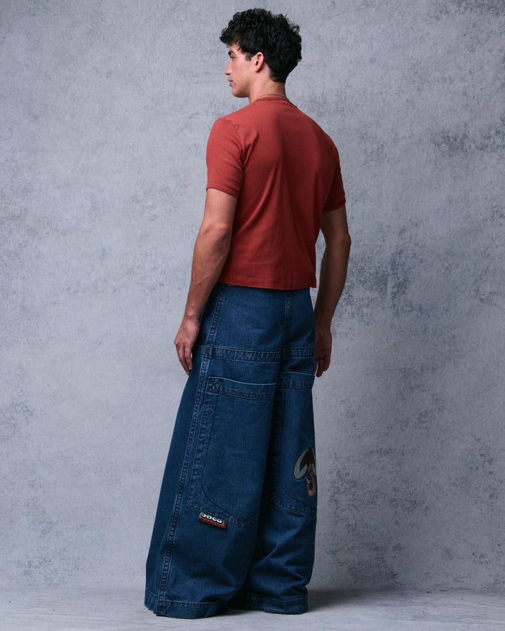 Model wearing dark stone wash extra-wide-leg jeans, rear angle showing back pockets and the brand tab