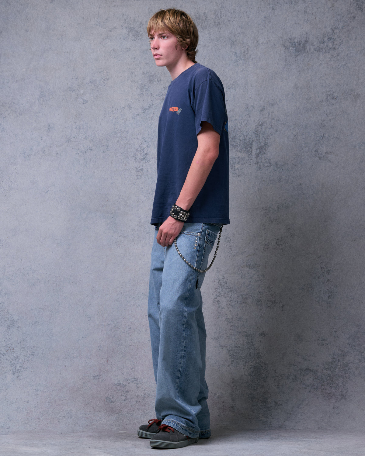 Model wearing light blue wide-leg jeans, three-quarter side view showing the front pocket and wallet chain