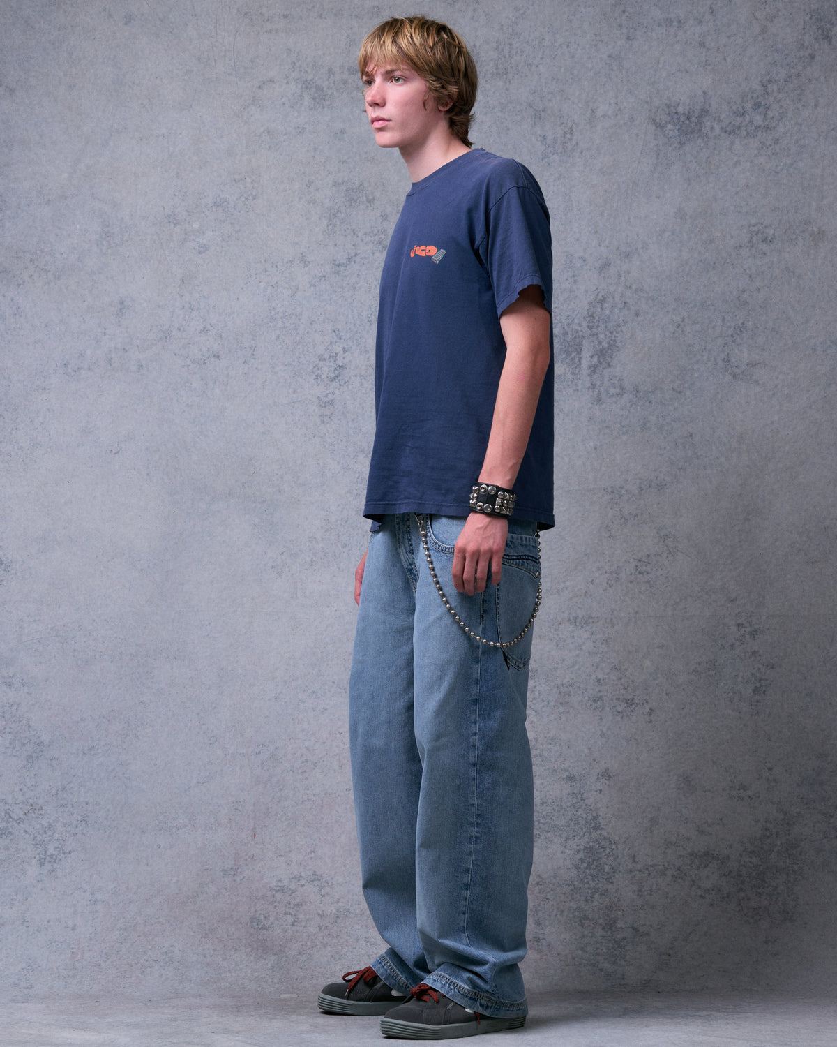 Model wearing light blue wide-leg jeans, angled side view from the left showing the full leg and hem