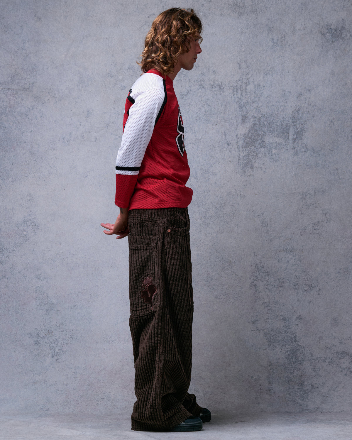 Model wearing brown wide-leg corduroy pants, side view showing the full leg width and crown J patch on the back pocket