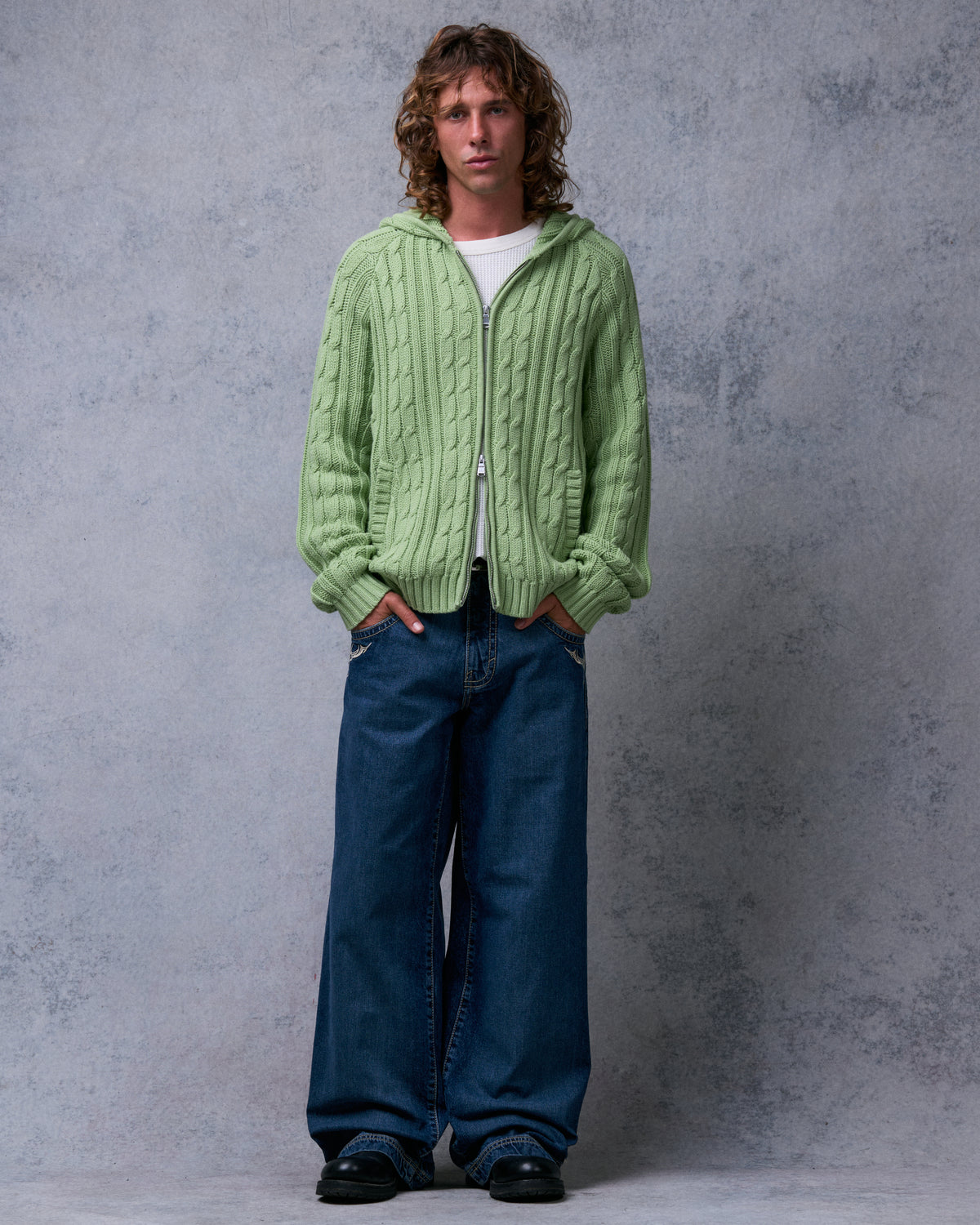 Model wearing dark stone wash wide-leg jeans, front view with hands in the front pockets