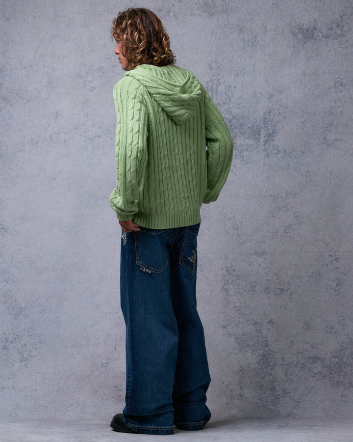 Model wearing dark stone wash wide-leg jeans, back three-quarter view showing tribal-embroidered back pockets