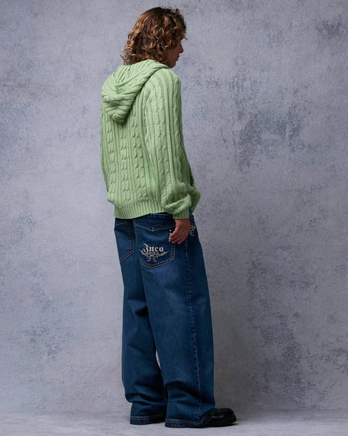 Back view of dark stone wash wide-leg jeans with white tribal Jnco embroidery on the back pocket