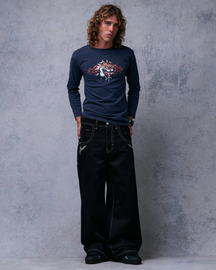 Model wearing black wide-leg jeans, front view, legs apart showing the wide hems over sneakers