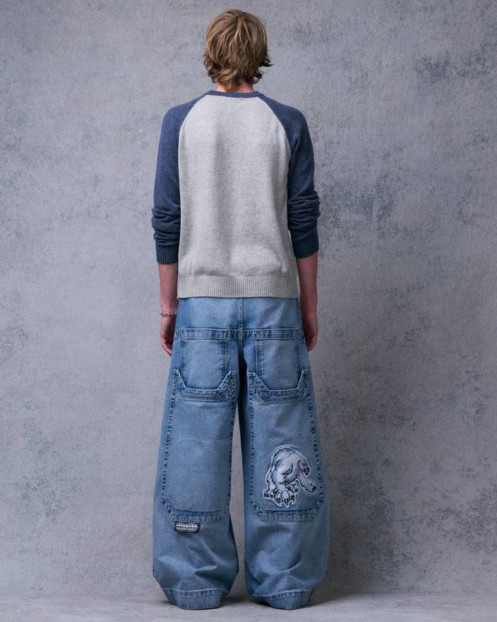 Model wearing the wide-leg jeans from behind, showing four back pockets and a polar bear patch on the right
