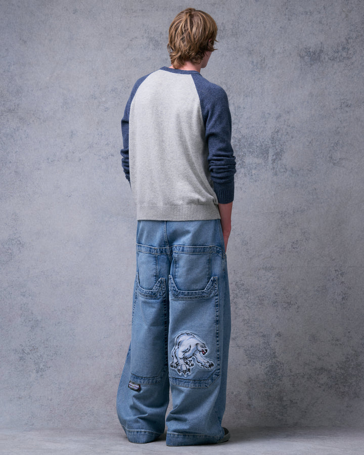 Model wearing light stone wash wide-leg jeans, back view showing four back pockets and a polar bear patch