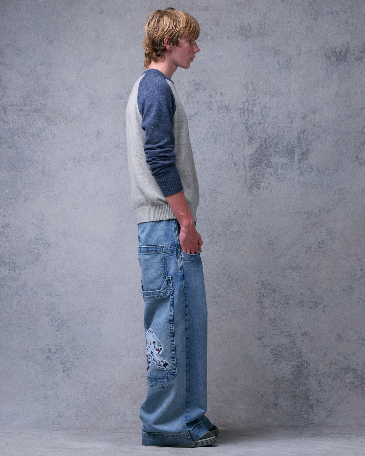 Model wearing light stone wash wide-leg jeans, side view with the polar bear patch on the back pocket